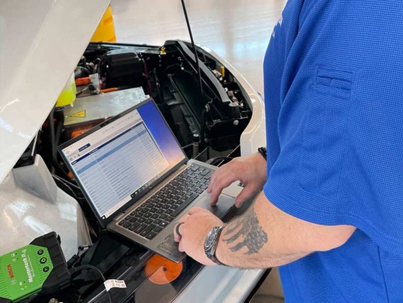 NGDV Aftermarket team member using a diagnostic tool and laptop.